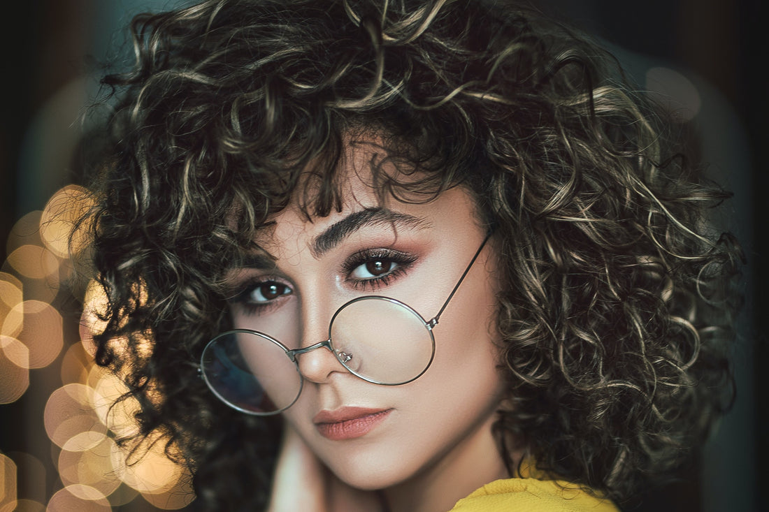 a woman with beautiful curly hair wearing glasses